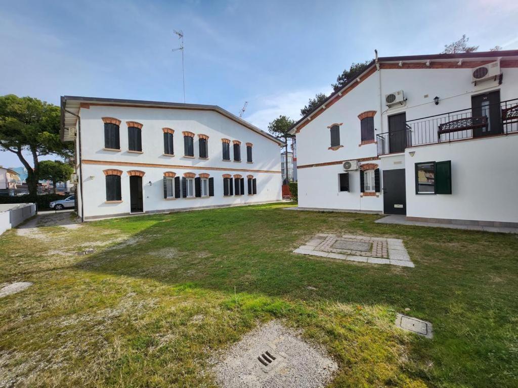 a large yard in front of two white buildings at Casette Baradel - Agenzia Caorle in Caorle