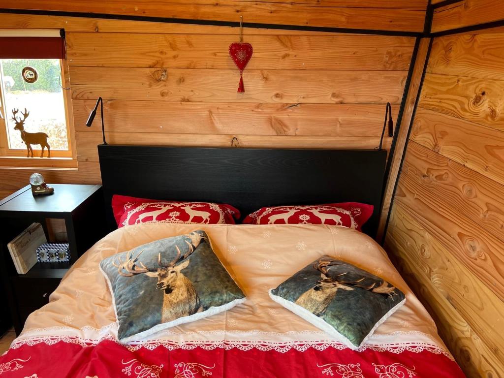 a bed with two pictures of a deer on it at Hoogte Huisje Tirol in Swalmen