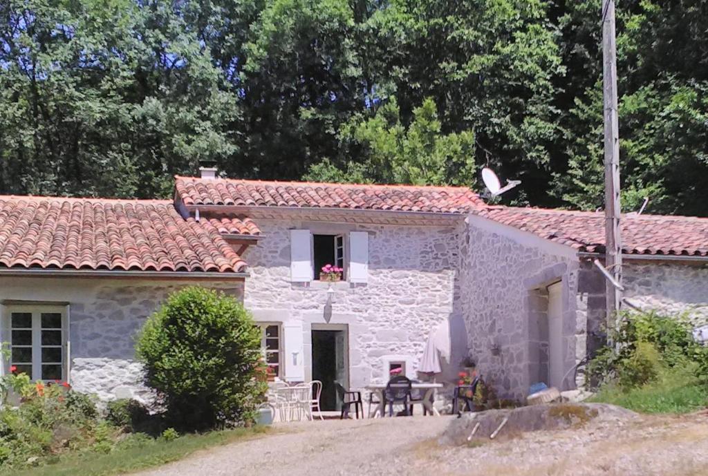 une petite maison en pierre blanche avec un toit rouge dans l'établissement Gîte le Coumis 1370, à Saint-Salvy-de-la-Balme