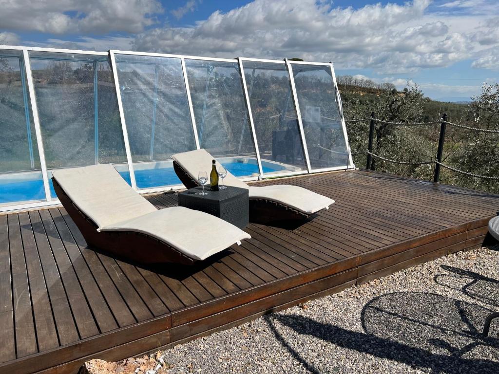 una terraza con 2 sillas, una mesa y una piscina en Villetta Toscana - Montepulciano, en Montepulciano
