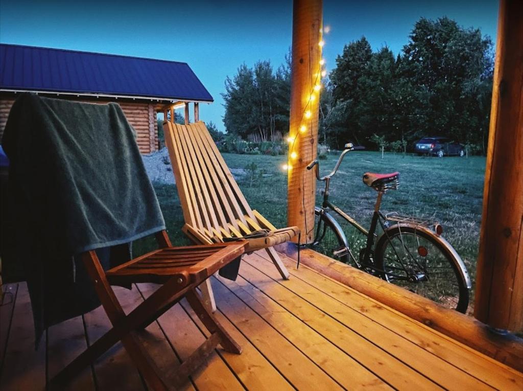 a rocking chair and a bike sitting on a porch at Vasaras Sapnis in Nidden