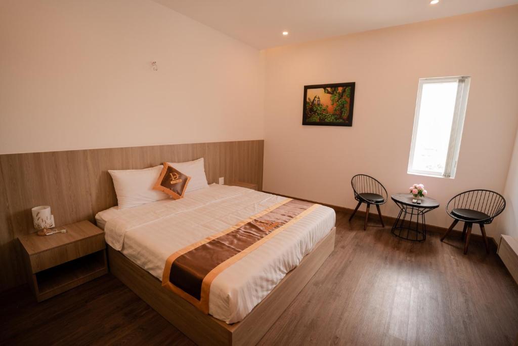 LÊ ĐOÀN HOTEL في راش غايا: غرفة نوم بسرير وكرسيين ونافذة