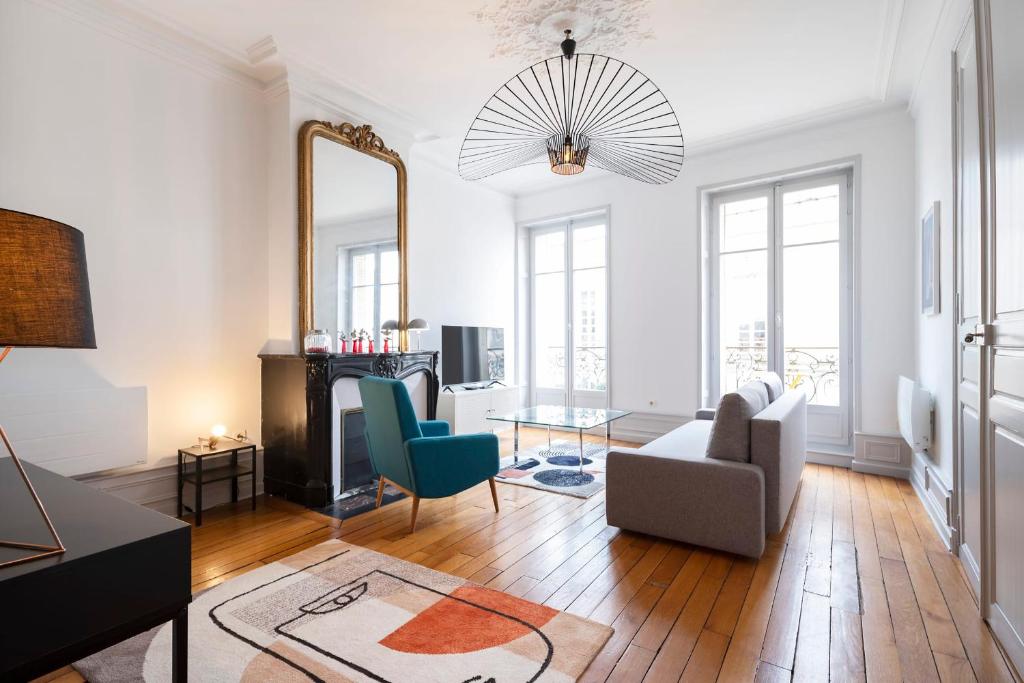 a living room with a couch and a mirror at L'Annexe de Stanislas in Nancy