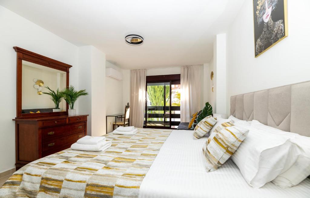a bedroom with a large white bed with pillows at Luxe Villa Puerto Banus in Marbella