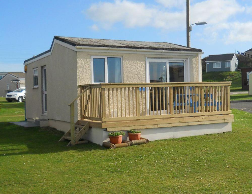 a small house with a large wooden deck at F62 Near Sea, Riviere Towans in Hayle