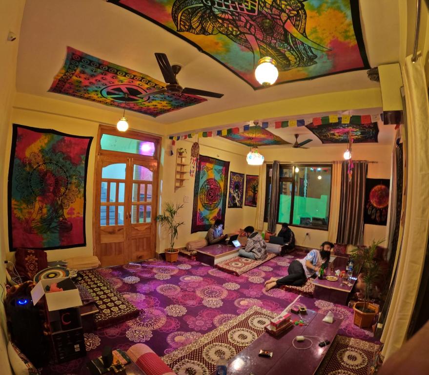 a living room with people sitting on the floor at Triumph bed and breakfast and cafe in Kasol
