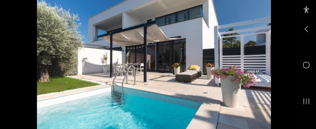 a swimming pool in front of a house at Villa Superior Two in Crikvenica