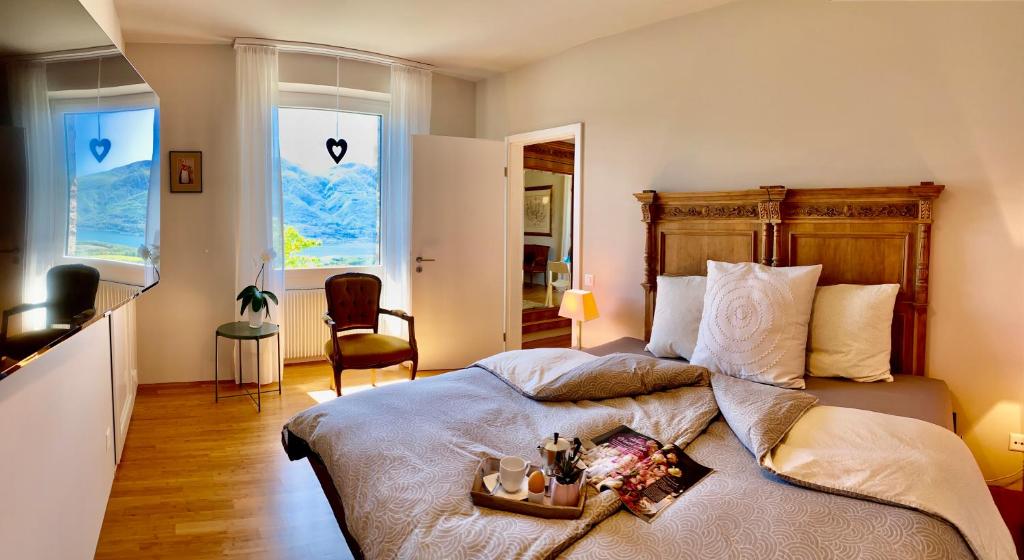 a bedroom with a large bed and two windows at Casa Sonora in Orselina