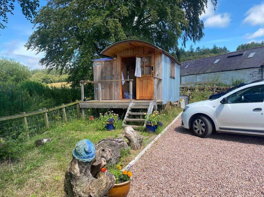 una pequeña casa con un coche aparcado delante de ella en Granny’s Hut en Thornhill