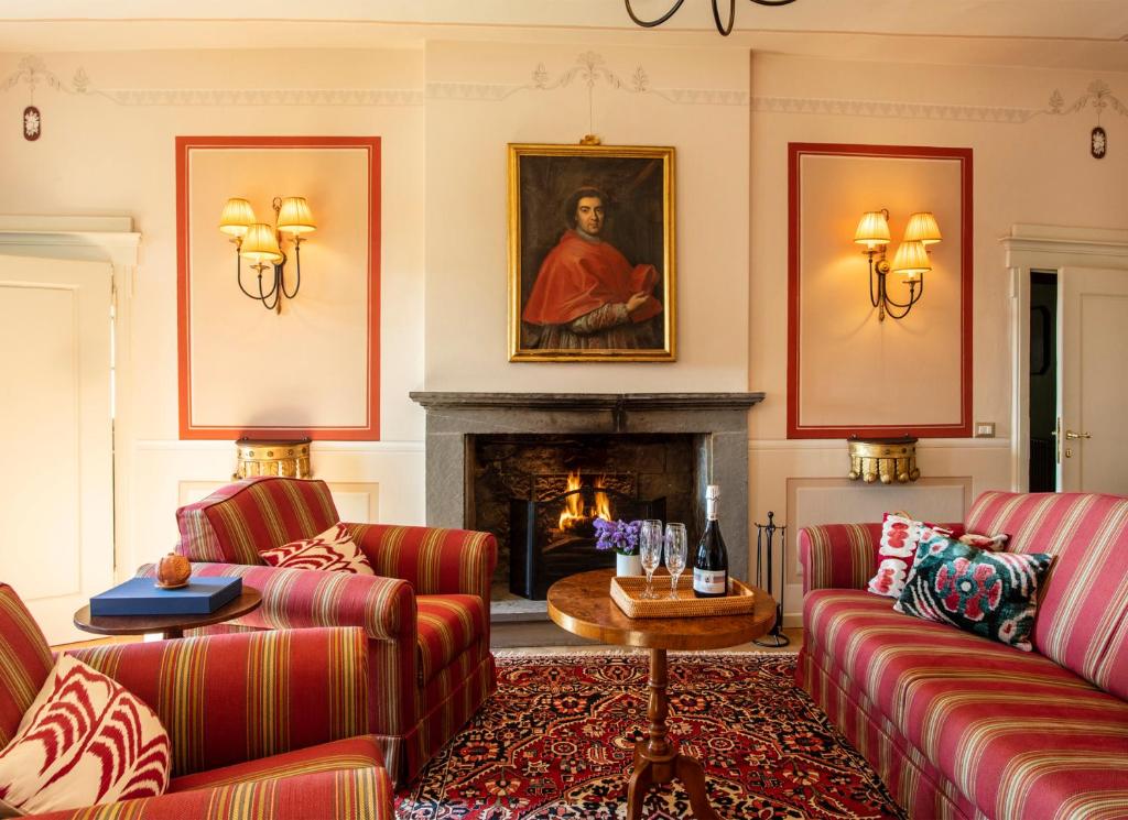 a living room with two couches and a fireplace at Palazzo Tiglio in San Pancrazio