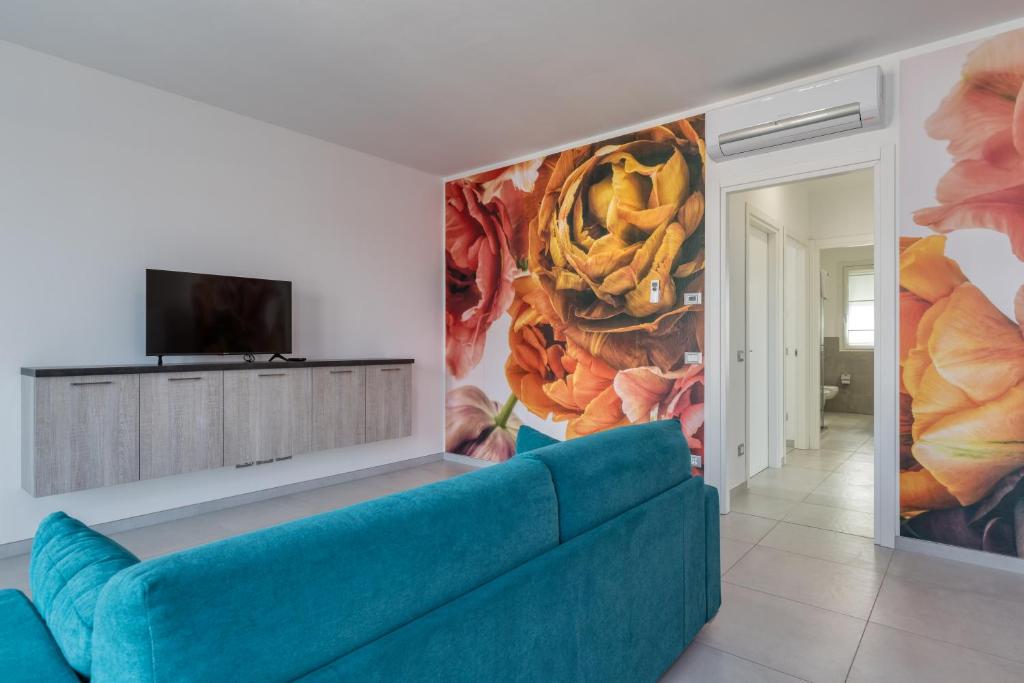 un sofá azul en una sala de estar con una pintura en Appartamenti Villa Campo Rosso en Colà di Lazise