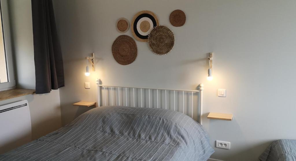 a bedroom with a bed and two hats on the wall at comme à la maison in Clonas-sur-Varèze