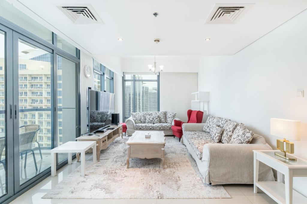 een woonkamer met 2 banken en een tv bij Lakeside Residence - 2BR Apartment - Allsopp&Allsopp in Dubai