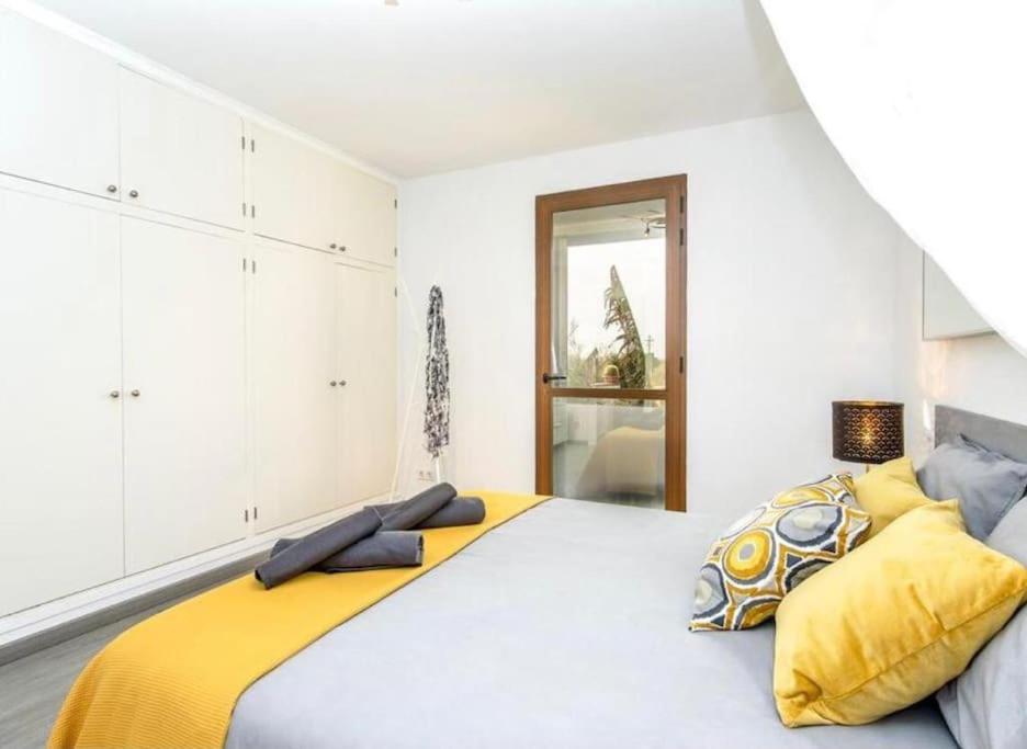 una camera da letto con un grande letto con cuscini gialli di Can Sastre a El Port