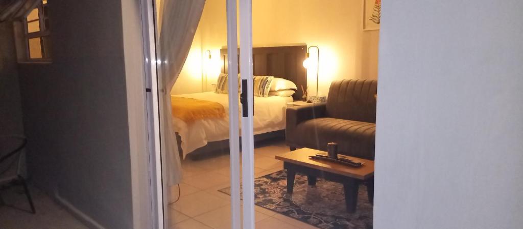 a hotel room with a bed and a living room at Dalau on Main in Paarl