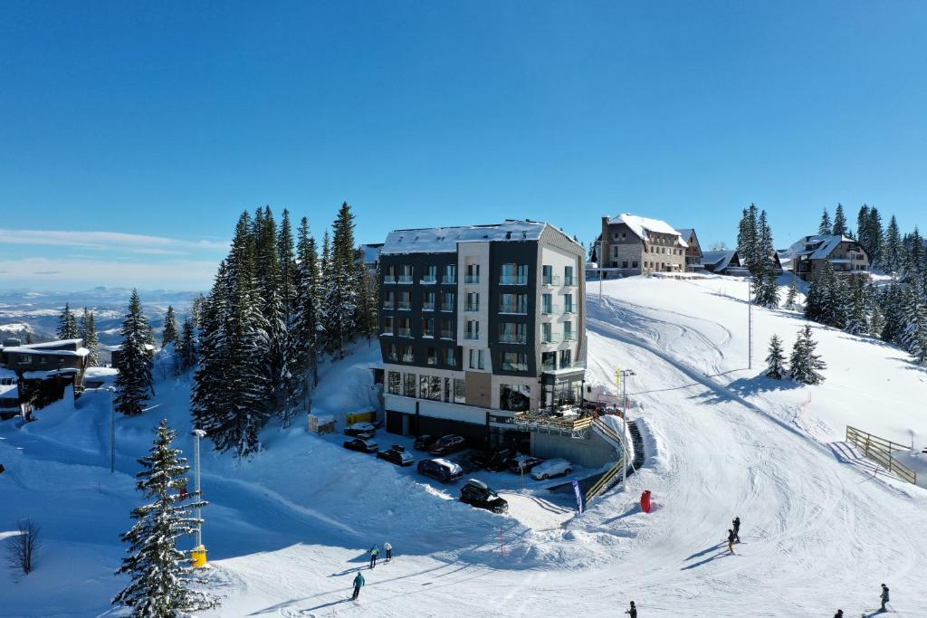 a building on top of a snow covered mountain at Aparthotel RAJSKA in Jahorina