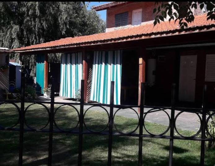 a fence in front of a house with colorful curtains at Departamentos Don Carlos in Villa Cura Brochero
