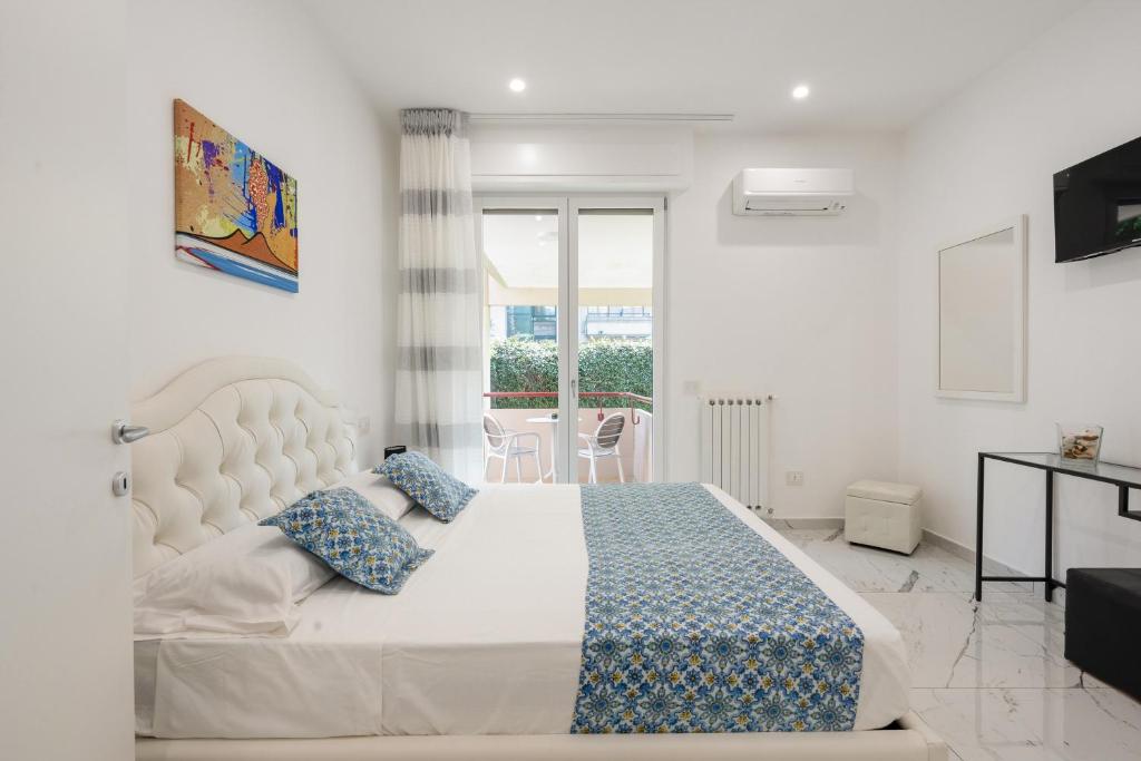 een slaapkamer met een groot wit bed met blauwe kussens bij Deluxe Suites in Piano di Sorrento