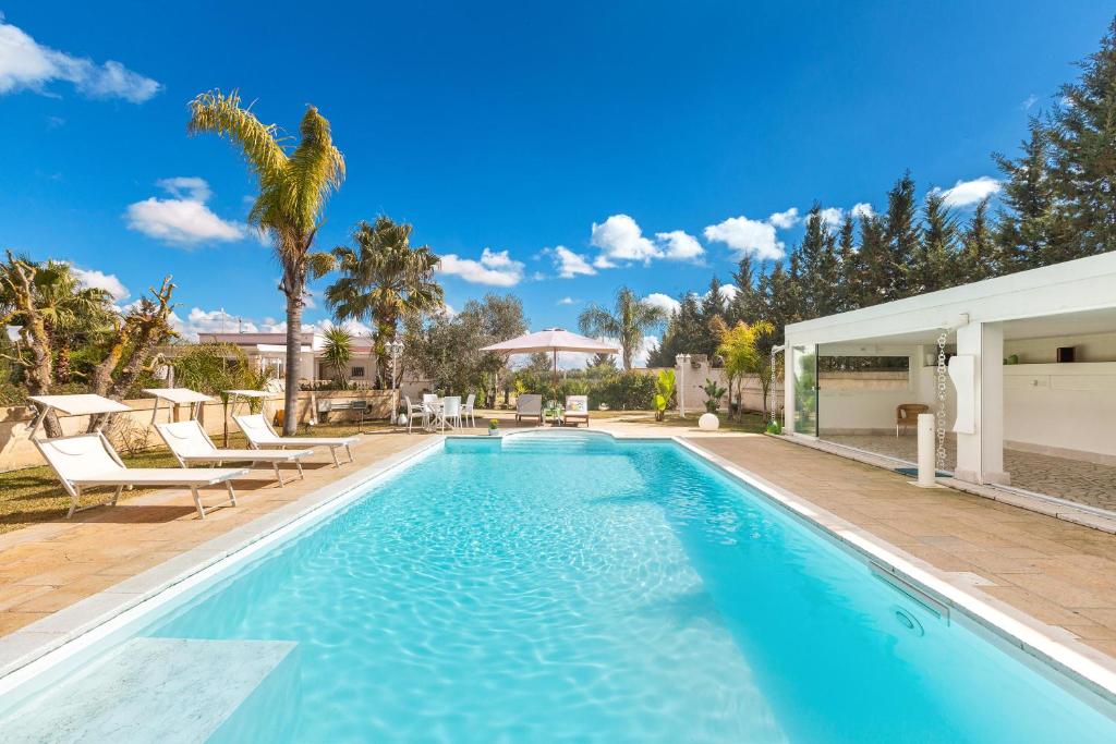 una piscina in una villa con una palma di Villa Smeralda by Perle di Puglia a San Pancrazio Salentino
