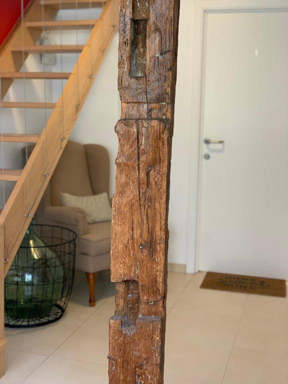 une poutre en bois dans un salon avec un escalier dans l'établissement Gite - Chez Joséphine, à Dambach-la-Ville