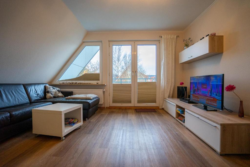 - un salon avec un canapé et une télévision dans l'établissement Haus Nordseetraum Wohnung 5, à Büsum