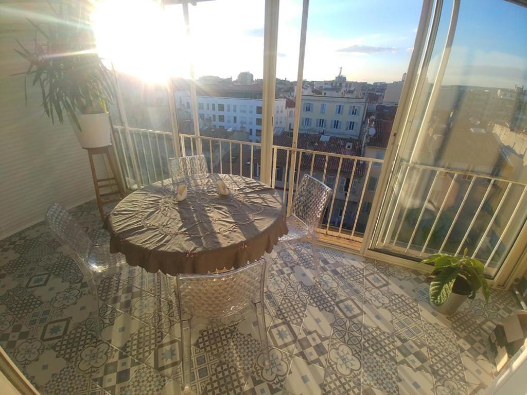 un balcon avec une table et des chaises sur un balcon dans l'établissement LOFT T3 90 m2 + TERRASSES - Accès direct plage/bus, à Marseille