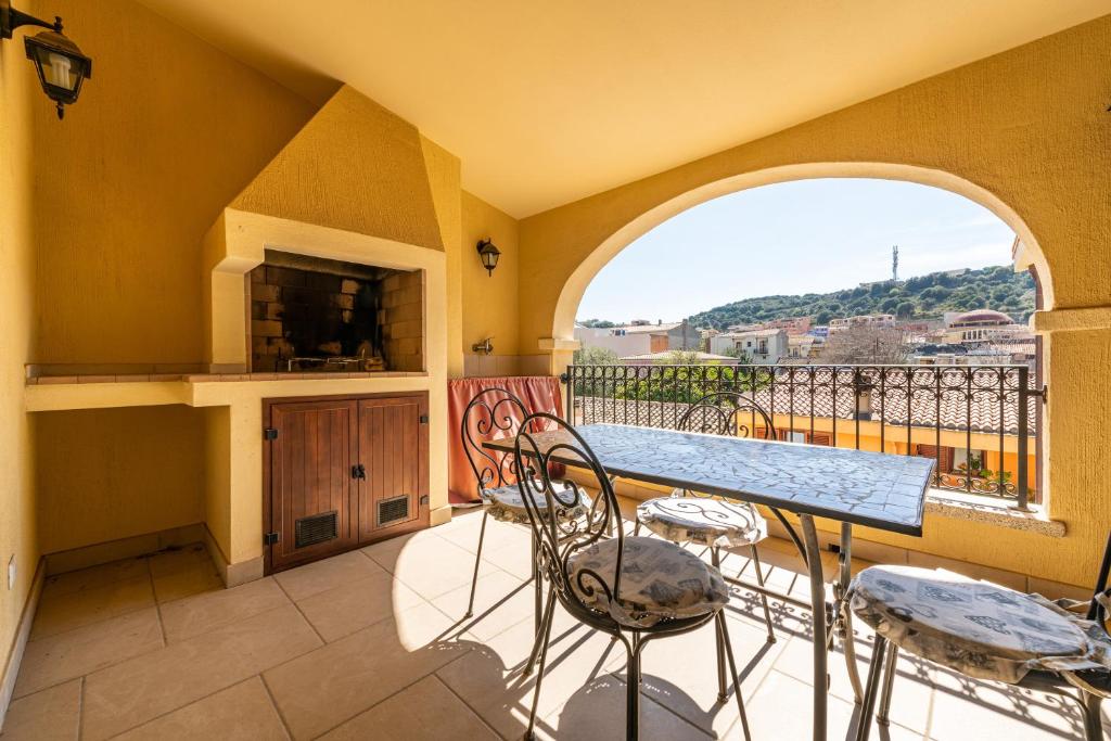 a balcony with a table and chairs and a window at Nuovo Attico in Centro in Villasimius