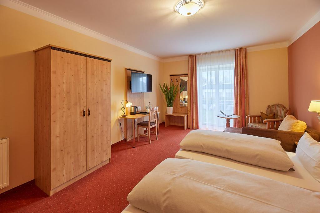 um quarto de hotel com duas camas e uma sala de estar em Hotel Gasthof Fellner em Furth im Wald