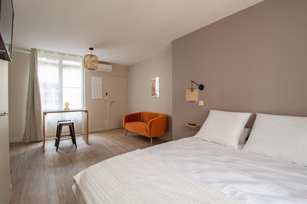 a bedroom with a bed and a desk and a chair at LE COURSARLON in Bourges