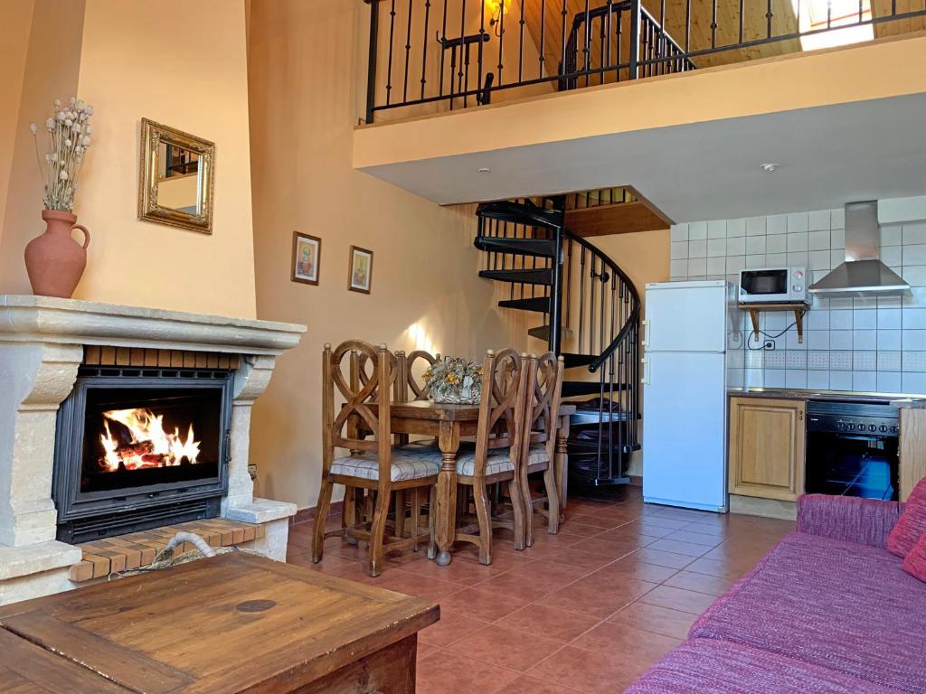 a living room with a table and a fireplace at Casas rurales Valle de El Paular in Rascafría