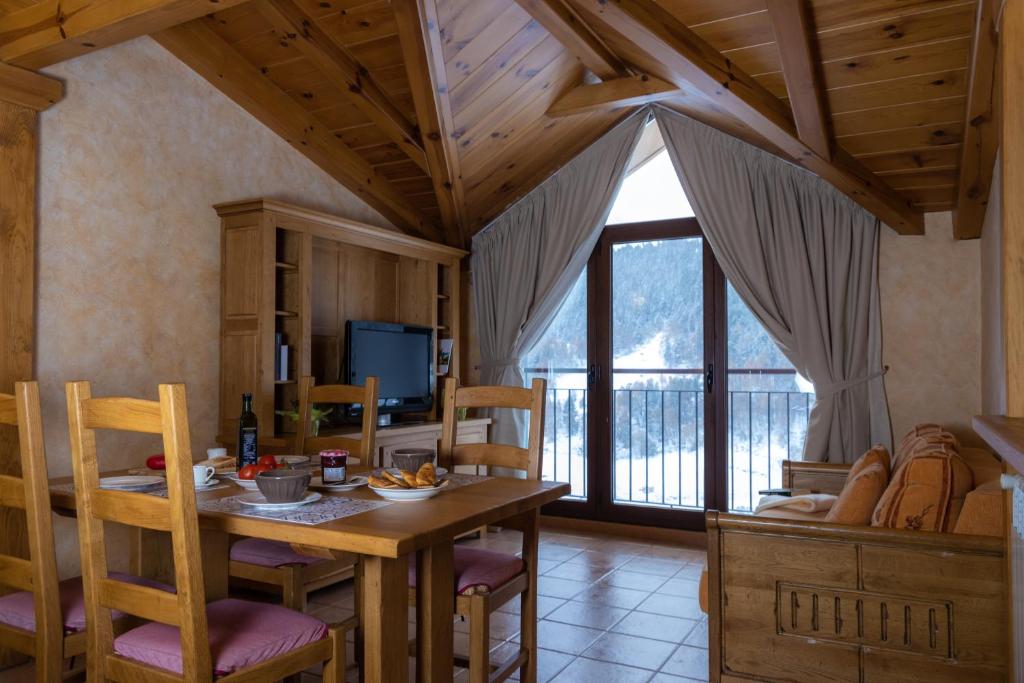 ein Esszimmer mit Tisch und Stühlen und einem Fernseher in der Unterkunft Apartaments Els Llacs in Bordes d´Envalira 