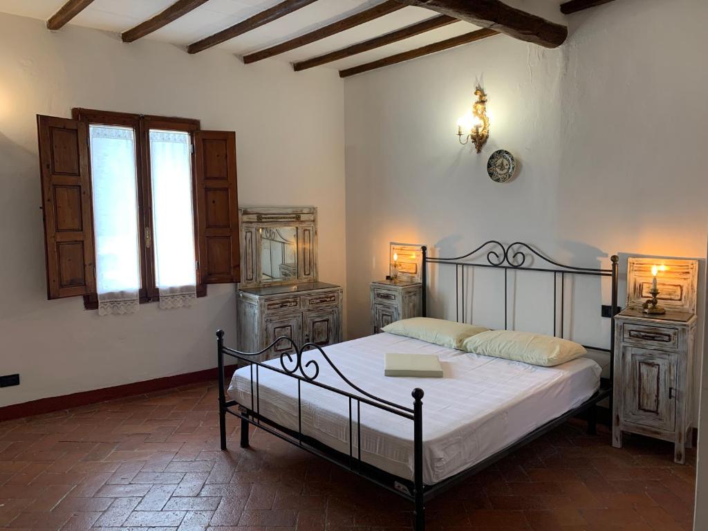 a bedroom with a bed and two dressers and a window at L'Attico dei Sogni in San Gimignano