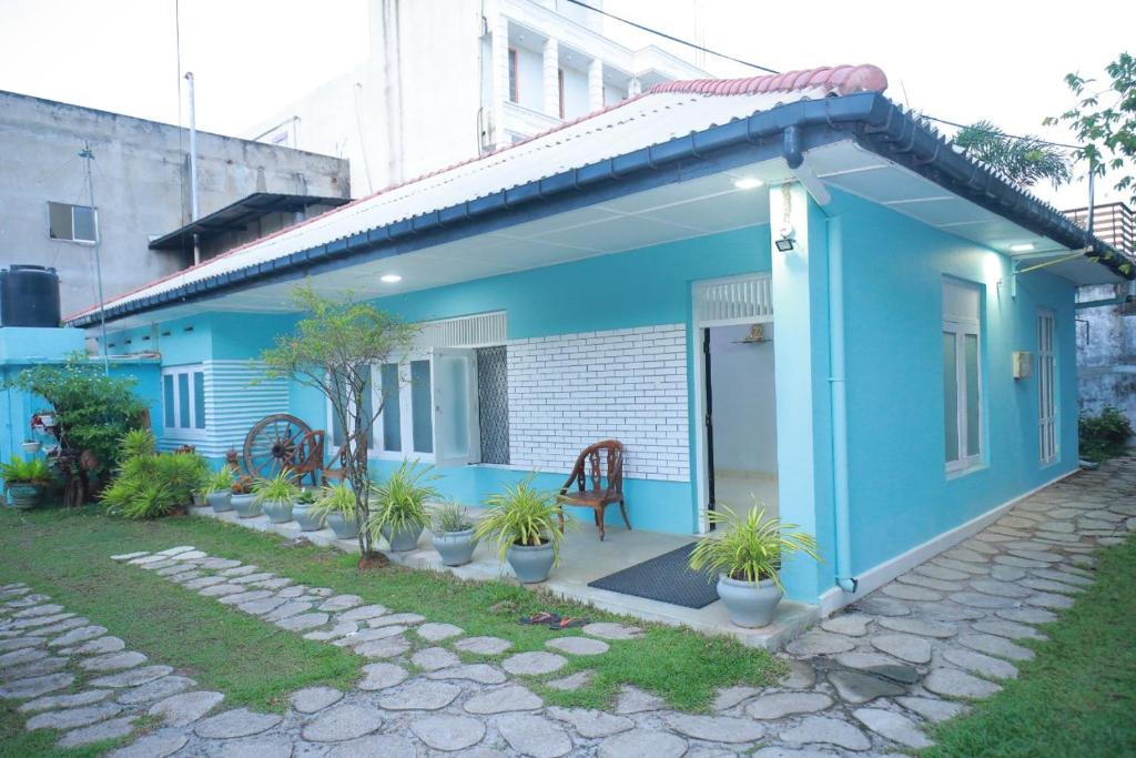 a blue house with potted plants in front of it at The Duchess Hotel in Matara