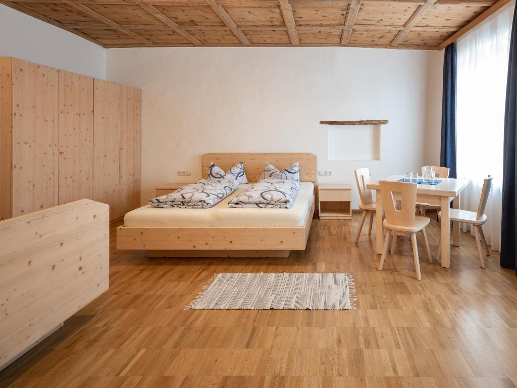 a bedroom with a bed and a table and a dining room at Vintlerhof in Bressanone
