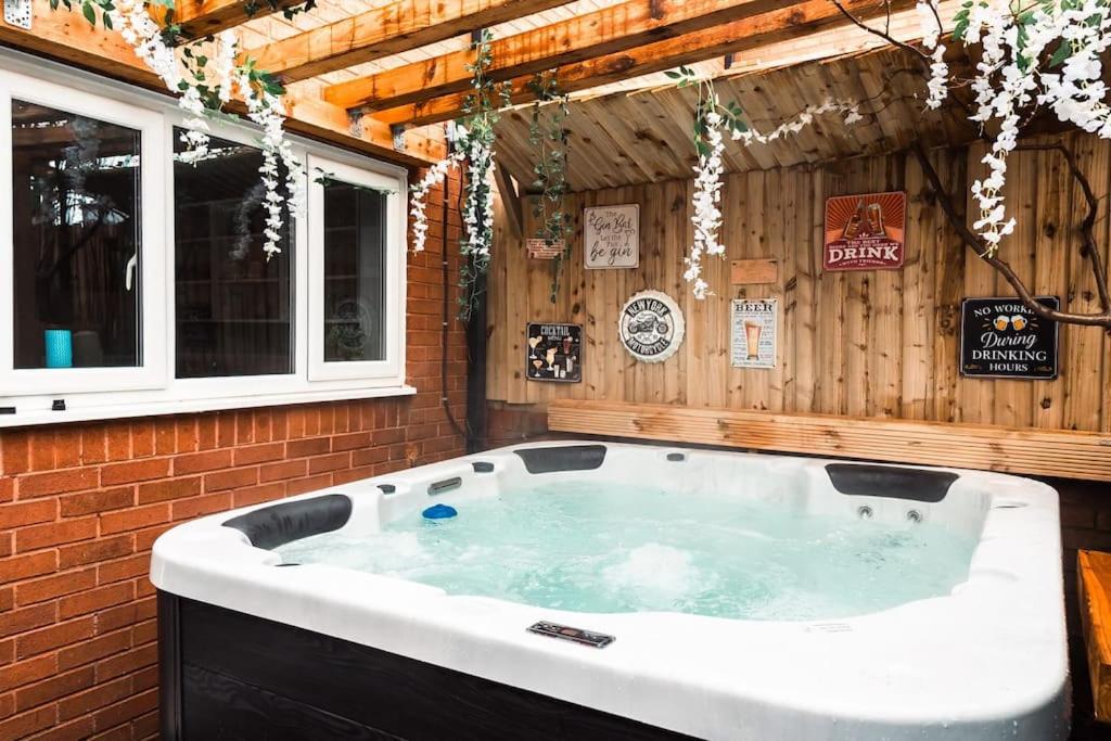 a jacuzzi tub in a room with a wooden wall at Elegant 2 bed with hot tub and a host of amenities in Liverpool