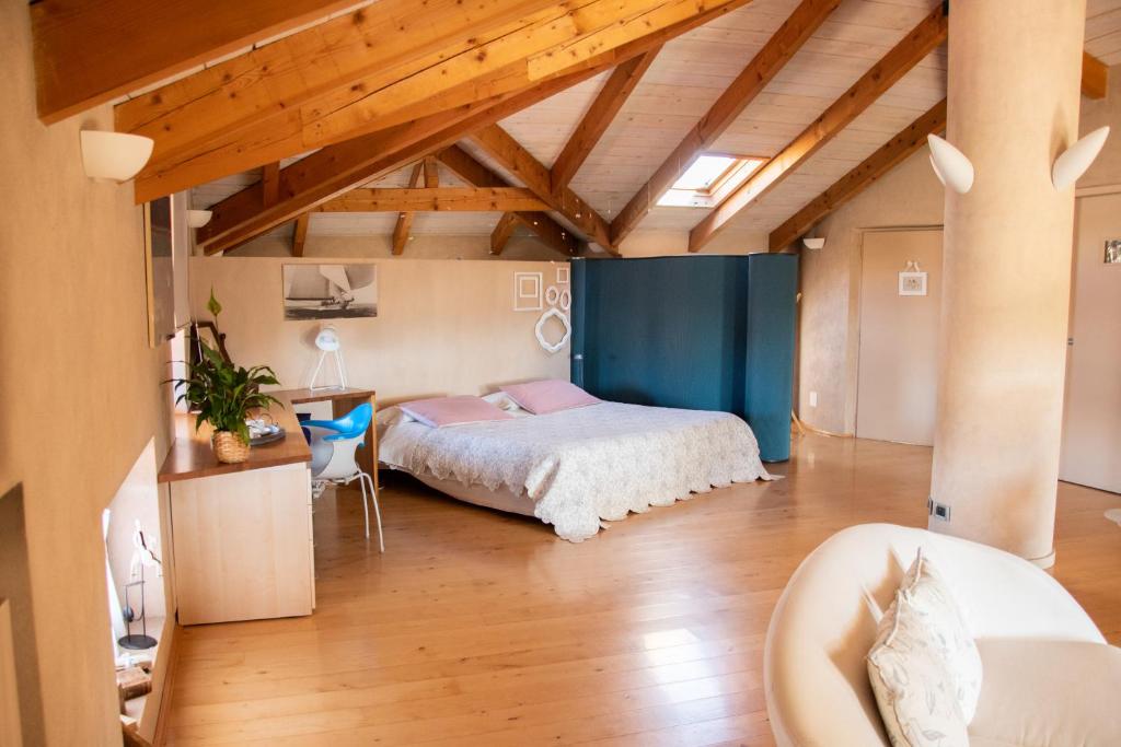 - une chambre avec un lit dans une pièce dotée de plafonds en bois dans l'établissement Il Gomitolo, à Biella