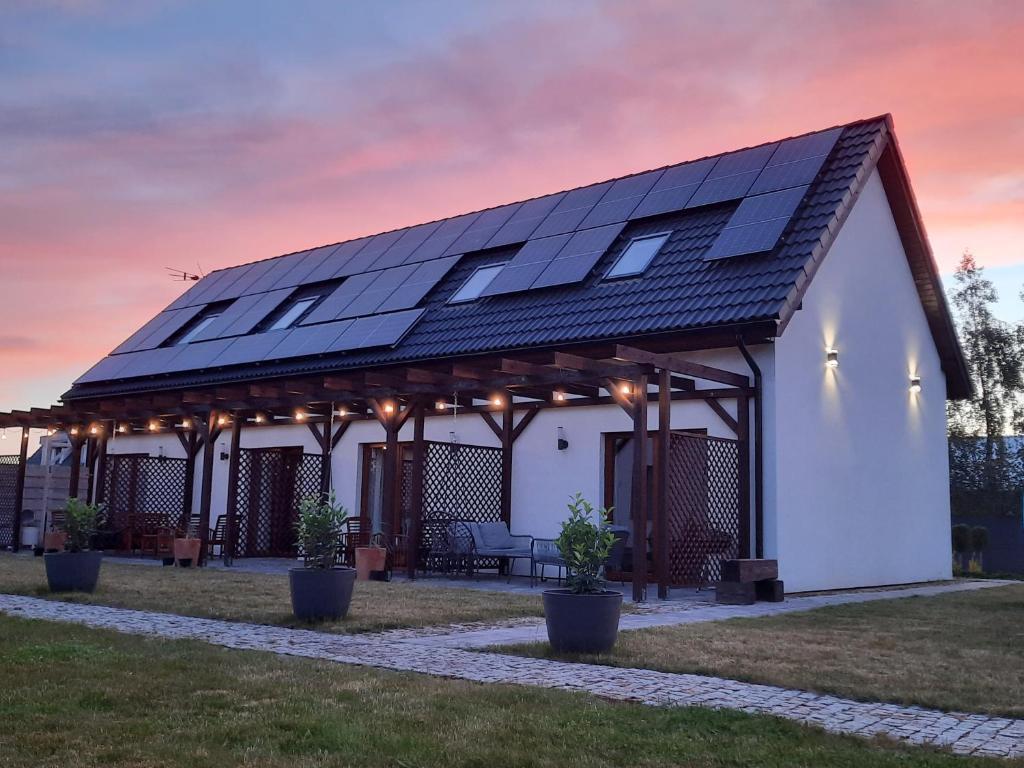 a house with solar panels on the roof at Apartamenty Nadmorska Osada in Łeba