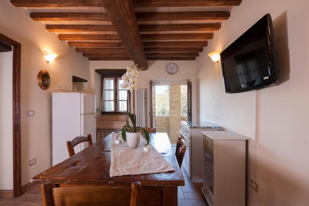 a kitchen with a wooden table and a television at La casina di Bonucci in Monte Santa Maria Tiberina