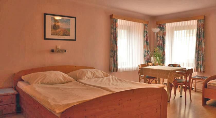 1 dormitorio con 1 cama, mesa y sillas en Frühstückspension Kammerer en Kleinpöchlarn