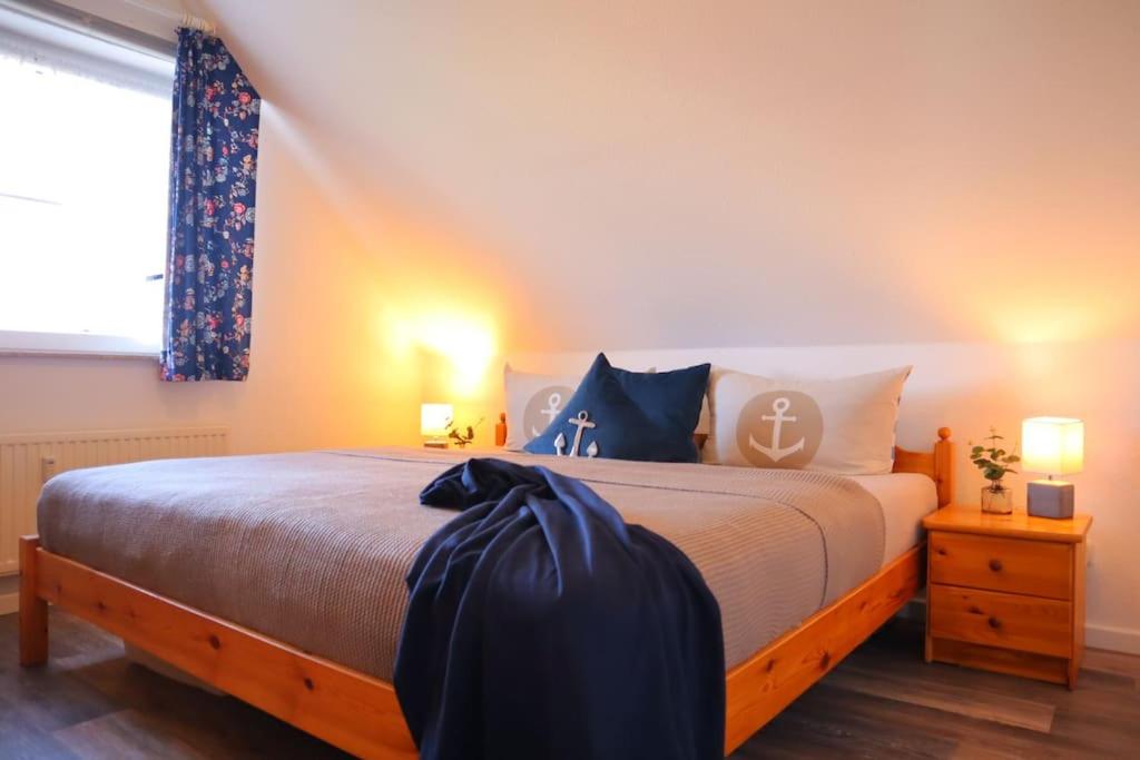a bedroom with a large bed with blue pillows at Ferienwohnung Nordseebrise in Spieka-Neufeld