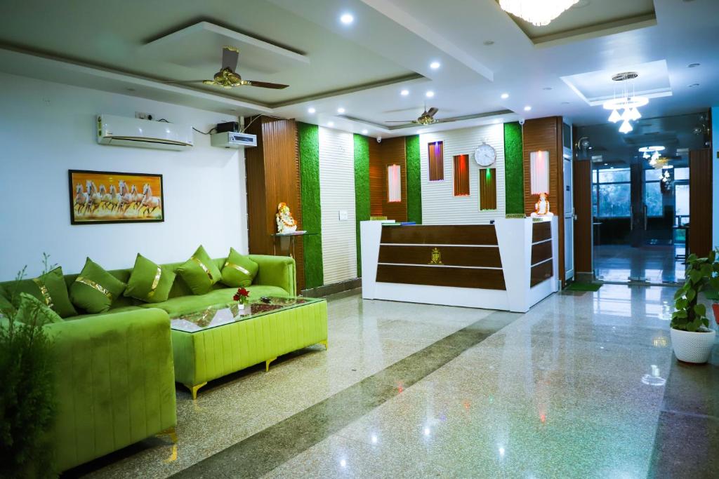 a lobby with a green couch and a table at Hotel SRP in Rishīkesh