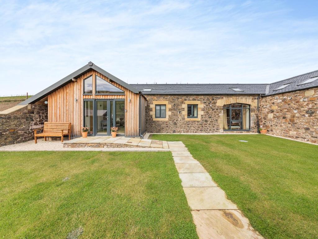 a stone house with a patio and a lawn at The Hemmel - Uk43357 in Branxton