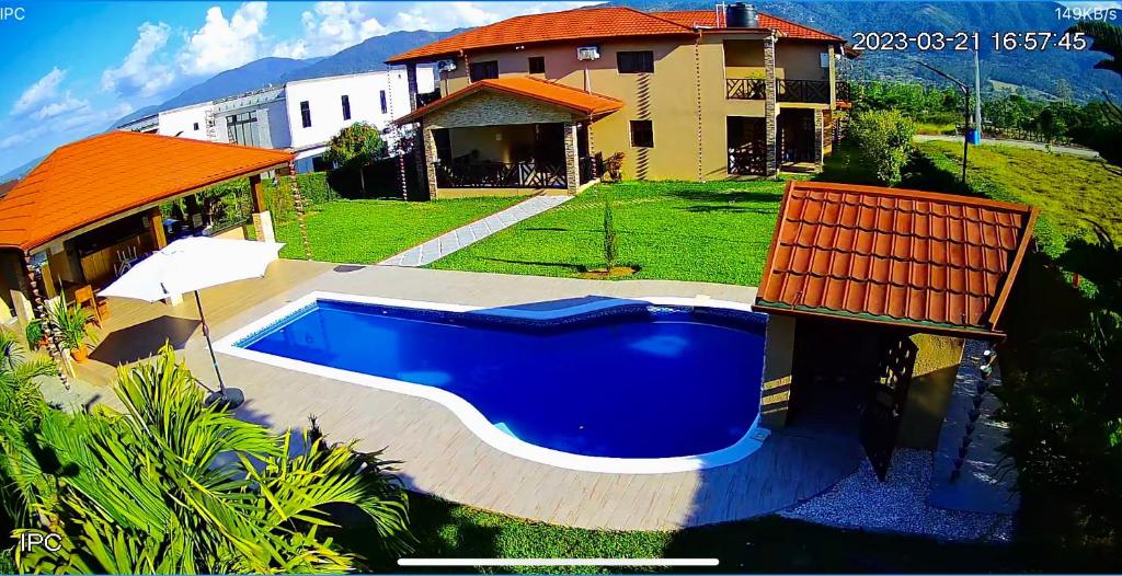 a large blue swimming pool in front of a house at ωιℓℓу'ѕ νιℓℓα in Jarabacoa