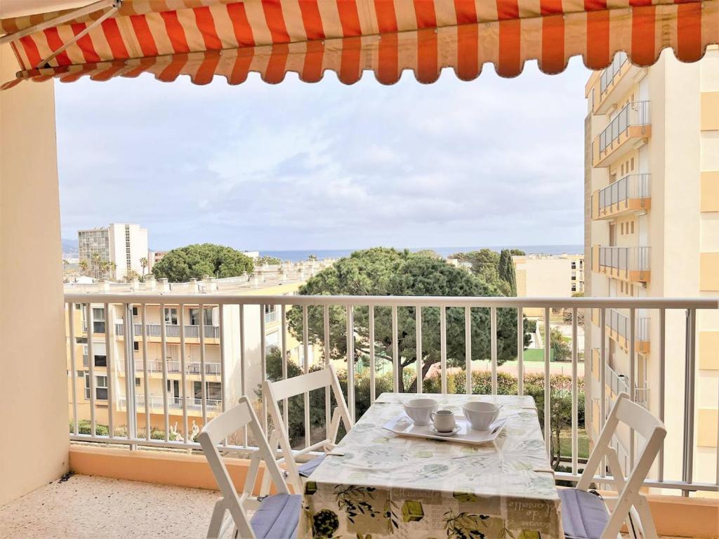 einen Tisch und Stühle auf einem Balkon mit Aussicht in der Unterkunft Appartement Le Lavandou, 1 pièce, 4 personnes - FR-1-251-481 in Le Lavandou