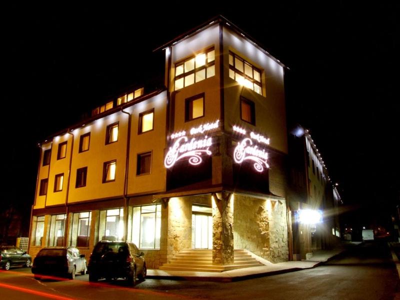 un edificio alto con luces encendidas por la noche en Gardenia Park Hotel en Bansko