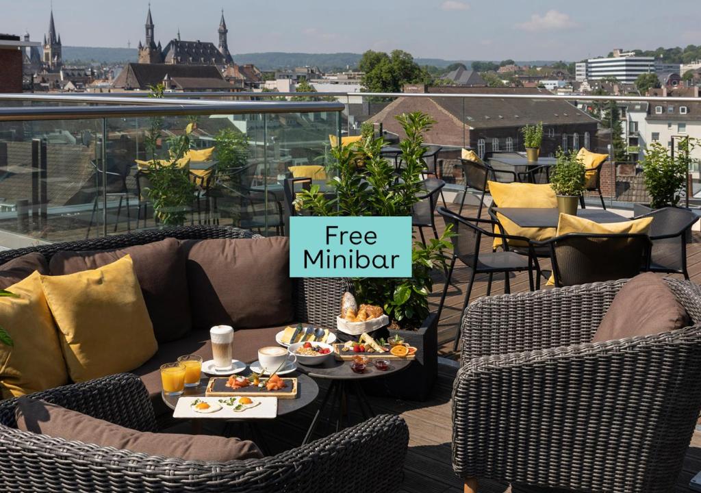 einen Balkon mit einem kostenlosen Denker-Schild auf einem Tisch mit Essen in der Unterkunft INNSiDE by Meliá Aachen in Aachen