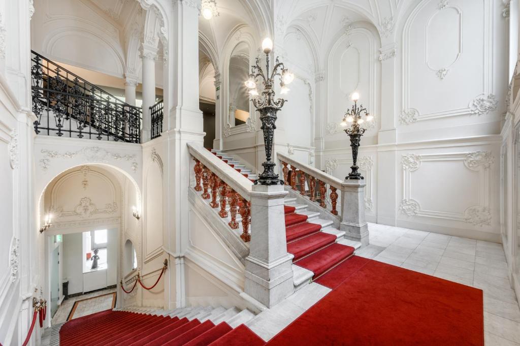 una escalera en un edificio con alfombra roja en Hotel Nemzeti Budapest - MGallery en Budapest