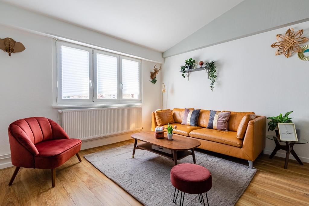 een woonkamer met een bank en een stoel bij Appart Premium aux Portes de Strasbourg avec Parking Privé in Schiltigheim