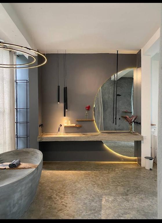 Un baño con lavabo y un espejo grande. en VODA Hotel, en Galle