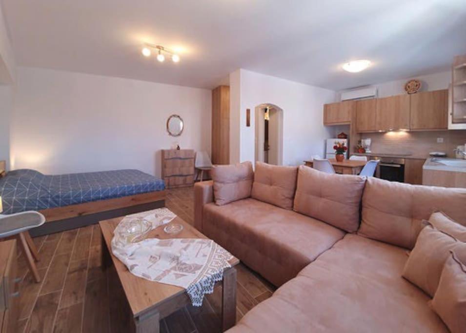 a living room with a couch and a kitchen at Kety’s house in Exámbela